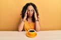 Beautiful middle age woman drinking a cup of coffee suffering from headache desperate and stressed because pain and migraine Royalty Free Stock Photo