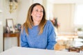 Beautiful middle age woman at home looking away to side with smile on face, natural expression Royalty Free Stock Photo