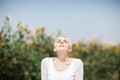 Beautiful middle age woman in a rural field scene outdoors with sunflowers