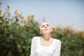 Beautiful middle age woman in a rural field scene outdoors with sunflowers