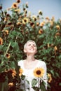 Beautiful middle age woman in a rural field scene outdoors with sunflowers