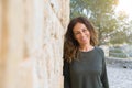 Beautiful middle age woman smiling cheerful leaning on a brick wall at the city street on a sunny day Royalty Free Stock Photo