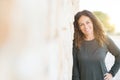 Beautiful middle age woman smiling cheerful leaning on a brick wall at the city street on a sunny day Royalty Free Stock Photo