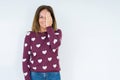 Beautiful middle age woman wearing heart sweater over isolated background covering one eye with hand with confident smile on face