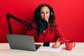 Beautiful middle age woman working at radio studio thinking attitude and sober expression looking self confident Royalty Free Stock Photo