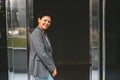 A beautiful middle-aged brunette woman stands in the doorway.