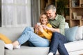 Beautiful Middle Aged Couple Using Mobile Phone And Embracing Together At Home Royalty Free Stock Photo