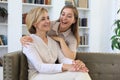 Beautiful middle aged mom and her adult daughter are hugging, looking at camera and smiling Royalty Free Stock Photo