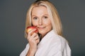 beautiful middle aged woman in bath robe with apple Royalty Free Stock Photo