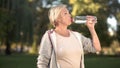 Beautiful middle aged woman drinking water after finishing her morning workout Royalty Free Stock Photo