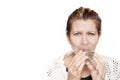 A beautiful middle-aged woman drinks water from a glass cup on a white background and smiles Royalty Free Stock Photo