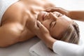 Beautiful middle aged woman enjoying face lifting massage in spa salon Royalty Free Stock Photo