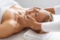 Beautiful middle aged woman enjoying rejuvenating face lifting massage at spa salon Royalty Free Stock Photo