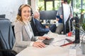 Beautiful middle aged woman with headphones working on computer in office Royalty Free Stock Photo