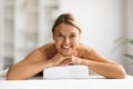 Beautiful middle aged woman lying on table in spa salon, waiting for massage Royalty Free Stock Photo