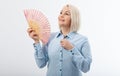 Beautiful middle aged woman with menopause blowing by fan. Hormone replacement therapy and mature woman healthcare. Mid age happy Royalty Free Stock Photo