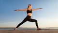 Beautiful Middle Aged Woman Practicing Yoga Outdoors, Standing In Warrior Pose Royalty Free Stock Photo