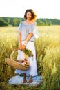 Beautiful middle-aged woman standing in a wheat field