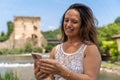 beautiful middle aged woman takes a selfie outdoors on a lakeside terrace