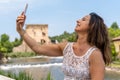 beautiful middle aged woman takes a selfie outdoors on a lakeside terrace