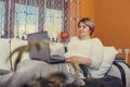 Beautiful middle aged woman using laptop and drinking tea