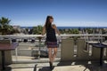 Beautiful Middle Aged Woman Watching Blue Ocean from Balcony with Deep Blue Sky. Long Brown Hair, Spaghetti Strap Top