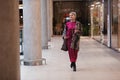 Beautiful middle aged Woman Wearing Fashionable Clothes long burgundy silk dress, leopard print coat jacket, black boots Royalty Free Stock Photo