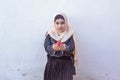 Beautiful middle-eastern girl holding pomegranate fruit. Cute Arabian Muslim woman received unique present