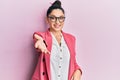 Beautiful middle eastern woman wearing business jacket and glasses smiling cheerful offering palm hand giving assistance and Royalty Free Stock Photo