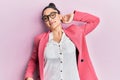 Beautiful middle eastern woman wearing business jacket and glasses stretching back, tired and relaxed, sleepy and yawning for
