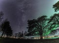 Beautiful Milky Way galaxy close to Aurora beside large pine trees, scenic photo of Northern Lights over calm night Stocksjo lake Royalty Free Stock Photo