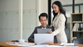 A beautiful millennial Asian businesswoman is briefing a male employee Royalty Free Stock Photo