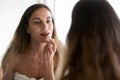 Young woman in towel doing makeup with red lipstick Royalty Free Stock Photo