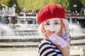 Beautiful mime girl in a mask of a sad clown on a background of blue sky on a sunny day