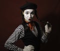 Beautiful mime girl smiles and holds her pigtails with her hands