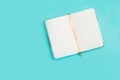 Beautiful miniature open Notepad on blue paper background. Office, work, minimal concept