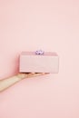 Beautiful minimal background with pink gift box in female hand on pink background