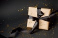 Beautiful minimal christmas, black friday golden black decor and paper craft gift box with satin black ribbon on dark black