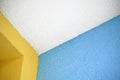 White ceiling edge with colorful blue and yellow walls, coated with roughcast Royalty Free Stock Photo