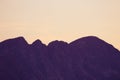 A beautiful, minimalist scenery of mountain sunset in purple tones. Abstract, colorful mountain landscape.