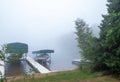 Beautiful Minnesota lake on a foggy morning with pleasure boats on shore Royalty Free Stock Photo
