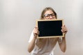 Beautiful mischievous girl with glasses holding a sign in her hands. copy-space