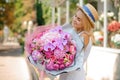 Beautiful mixed flower bouquet hold by smiling woman. Selective focus