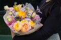 Beautiful mixed flowers bouquet with yellow and pink roses in the hands Royalty Free Stock Photo