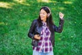 Beautiful mixed race young woman listening to music on headphones with smartphone. Hispanic hipster girl dancing to Royalty Free Stock Photo