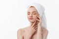 Beautiful model applying cosmetic cream treatment on her face on white. Royalty Free Stock Photo