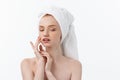 Beautiful model applying cosmetic cream treatment on her face on white. Royalty Free Stock Photo
