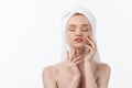 Beautiful model applying cosmetic cream treatment on her face on white. Royalty Free Stock Photo