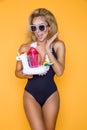 Beautiful model in a bikini and sunglasses, holding a drink and an inflatable unicorn. Royalty Free Stock Photo