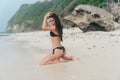 Beautiful model in black swimsuit posing on white sandy beach Royalty Free Stock Photo